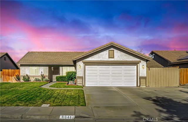 single story home with a garage and a lawn