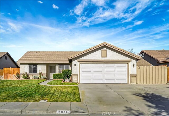 ranch-style home with a garage and a front lawn