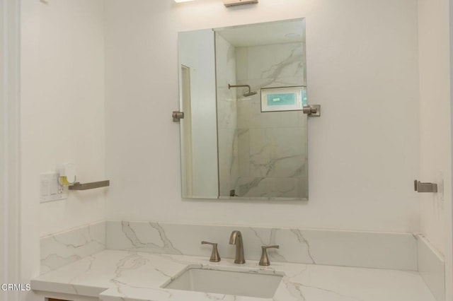 bathroom with vanity and a tile shower