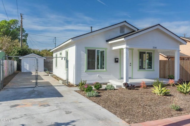 bungalow-style home with covered porch and a shed