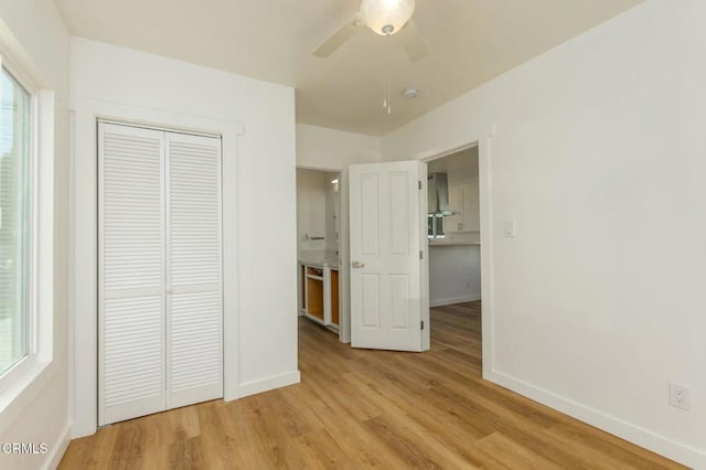 unfurnished bedroom with ceiling fan, a closet, and light hardwood / wood-style flooring