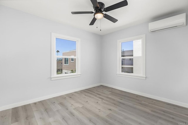 unfurnished room featuring a wall mounted air conditioner, ceiling fan, and light wood-type flooring