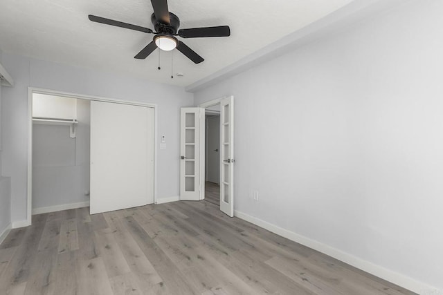 unfurnished bedroom featuring ceiling fan, a closet, and light wood-type flooring