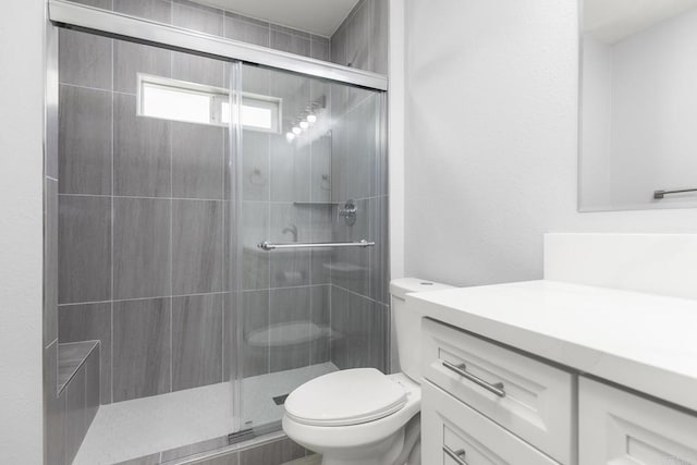 bathroom featuring walk in shower, vanity, and toilet