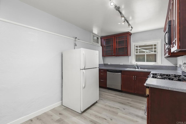 kitchen featuring appliances with stainless steel finishes, track lighting, light hardwood / wood-style flooring, and sink