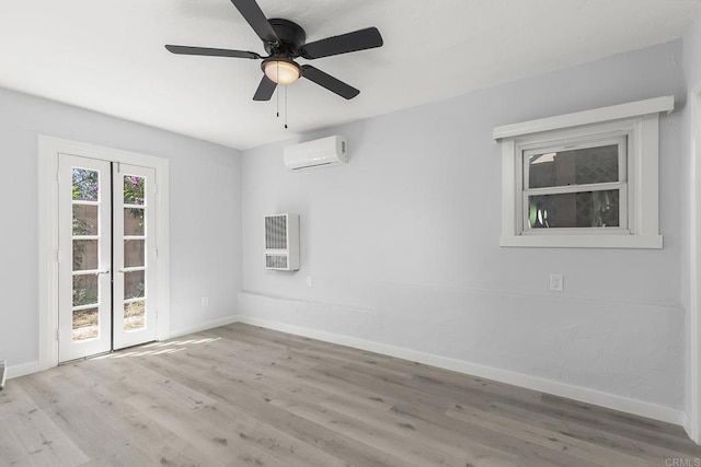 empty room featuring a wall mounted AC, ceiling fan, heating unit, and light wood-type flooring