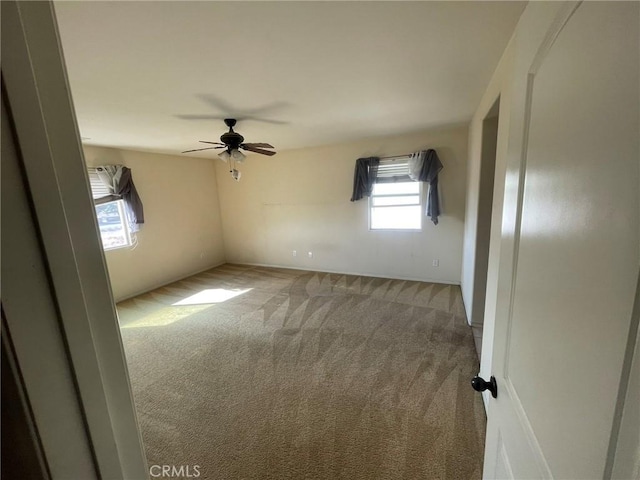 carpeted empty room featuring ceiling fan