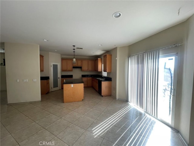 kitchen featuring decorative light fixtures, light tile patterned floors, and a kitchen island