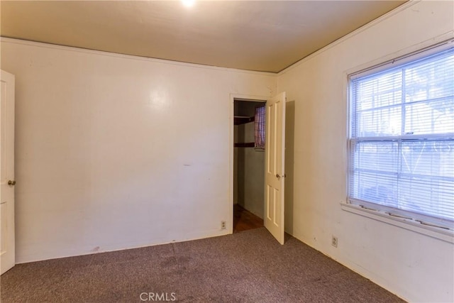 unfurnished bedroom featuring a closet and dark carpet