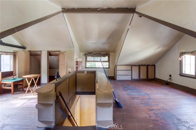 bonus room with dark hardwood / wood-style flooring and lofted ceiling with beams