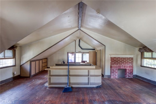 additional living space featuring a fireplace, dark hardwood / wood-style flooring, vaulted ceiling, and plenty of natural light