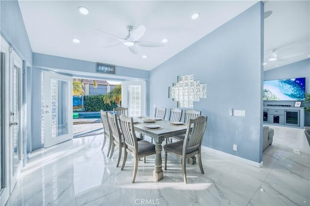 dining area featuring wine cooler, ceiling fan with notable chandelier, and lofted ceiling