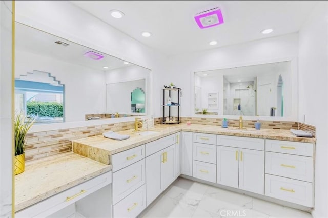 bathroom with tasteful backsplash, a shower with door, and vanity