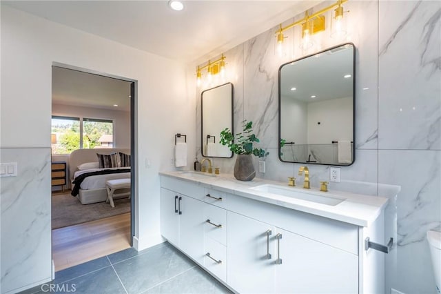 bathroom featuring wood-type flooring, vanity, toilet, and tile walls