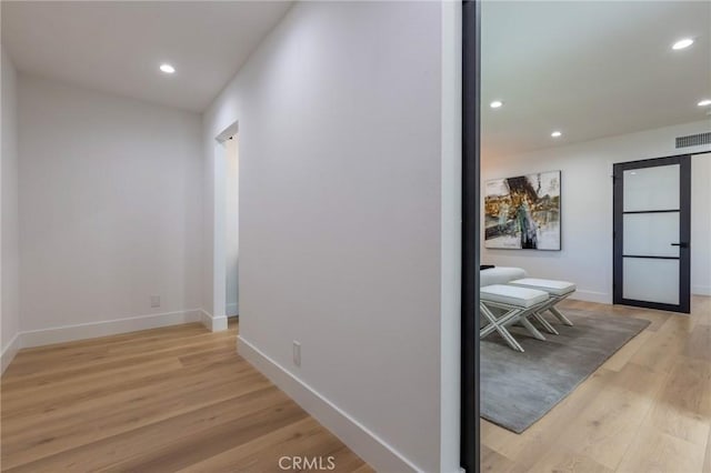 hallway with light hardwood / wood-style floors