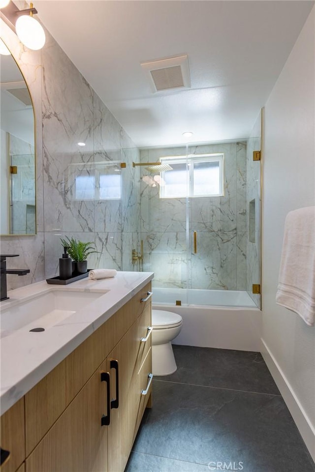 full bathroom featuring shower / bath combination with glass door, vanity, toilet, and tile patterned flooring