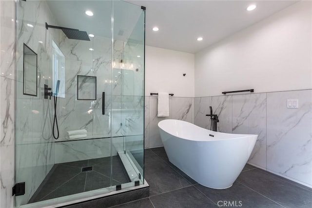 bathroom with tile patterned floors, independent shower and bath, and tile walls