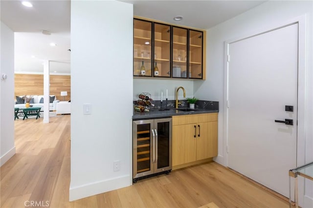 bar with light hardwood / wood-style floors, sink, and wine cooler