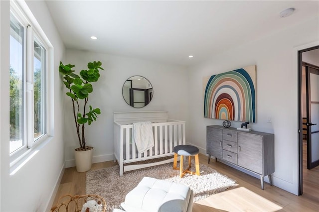 bedroom featuring a crib and light wood-type flooring