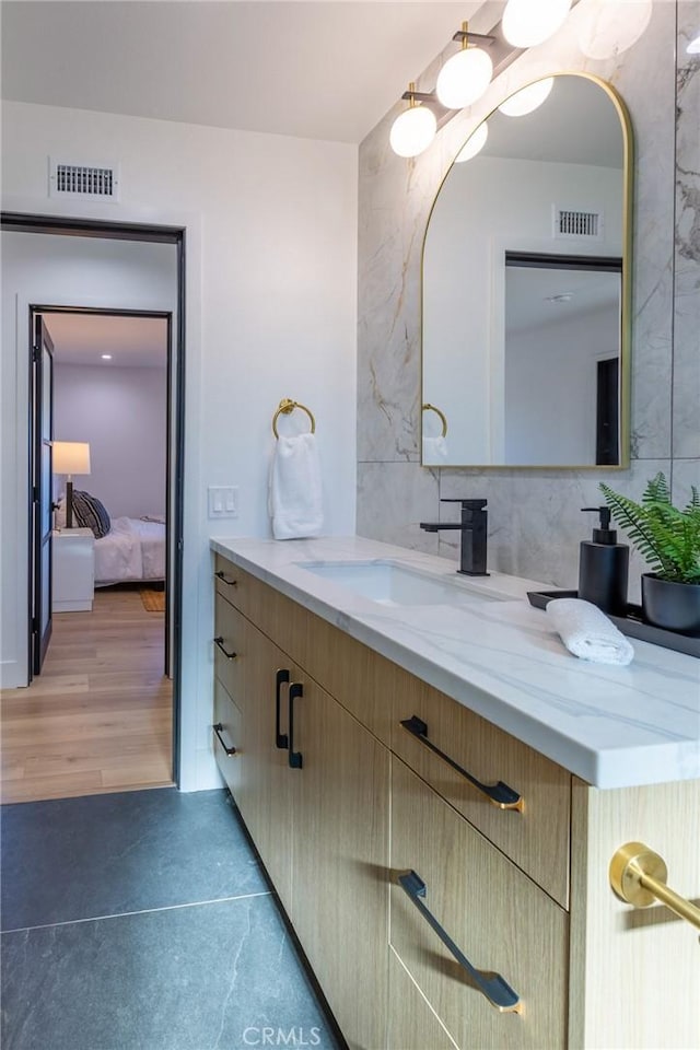 bathroom with decorative backsplash, hardwood / wood-style floors, and vanity