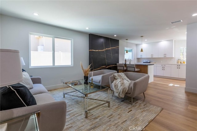 living room with a wealth of natural light and light hardwood / wood-style flooring