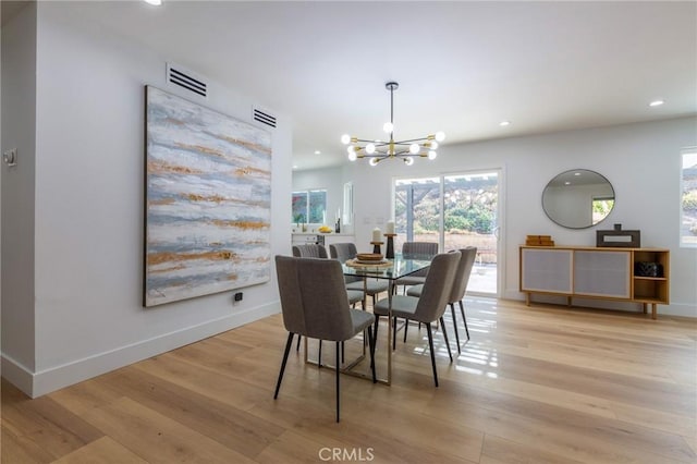 dining space featuring a chandelier and light wood-type flooring