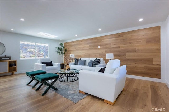 living room with light wood-type flooring and wood walls