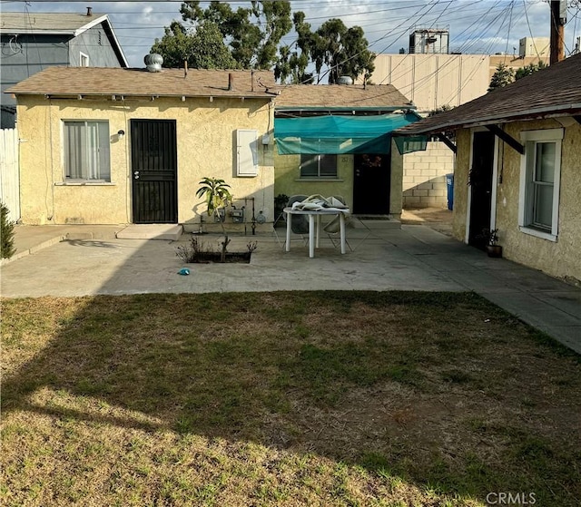 rear view of house featuring a patio area and a yard