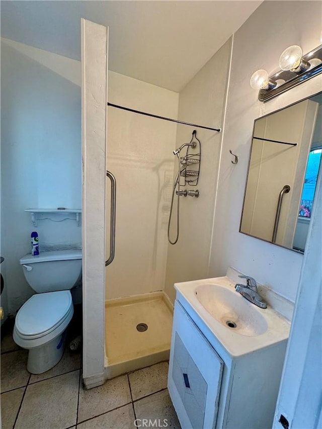 bathroom with a shower, vanity, tile patterned floors, and toilet