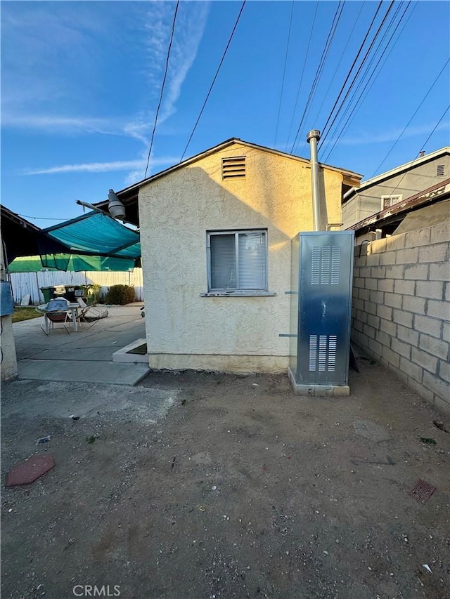 view of property exterior with a patio area