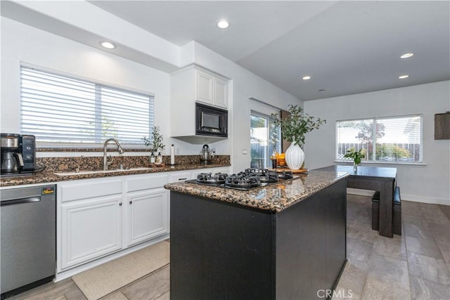 kitchen with a center island, stainless steel dishwasher, gas cooktop, sink, and white cabinets