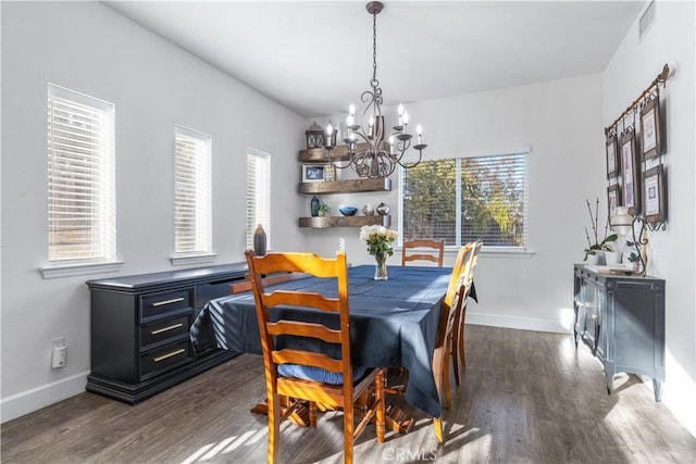 dining space featuring an inviting chandelier, dark hardwood / wood-style flooring, and a healthy amount of sunlight
