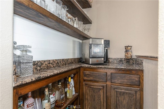kitchen with dark brown cabinets and dark stone counters