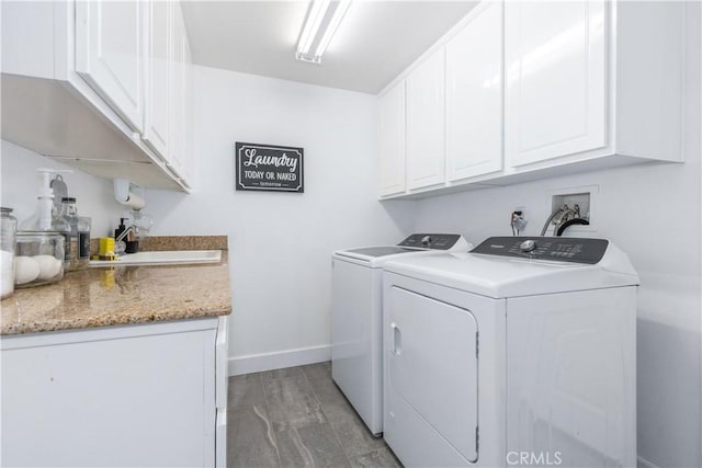 laundry room featuring washer and clothes dryer, sink, and cabinets