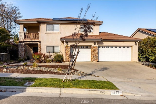 view of front of home featuring a balcony, a garage, and solar panels