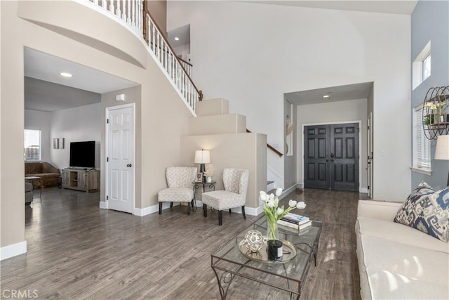 living room featuring dark hardwood / wood-style flooring and a towering ceiling