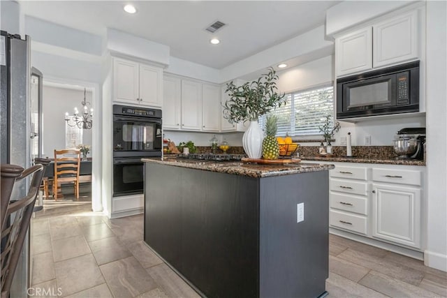 kitchen featuring black appliances, white cabinets, dark stone countertops, and a kitchen island