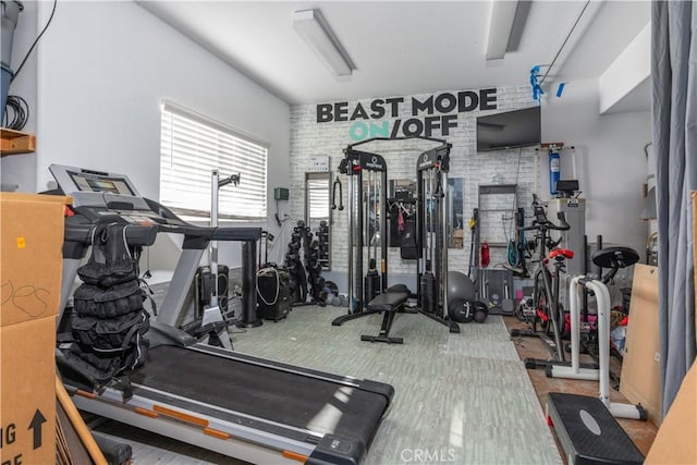 exercise room featuring brick wall