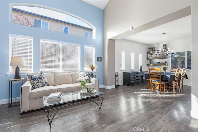 living room with an inviting chandelier, a healthy amount of sunlight, and dark hardwood / wood-style floors
