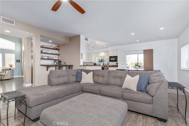 living room featuring ceiling fan and light wood-type flooring