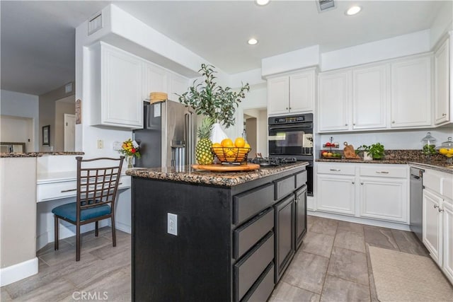kitchen featuring a center island, black double oven, white cabinetry, dark stone countertops, and high end refrigerator