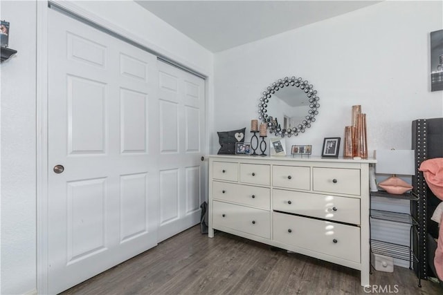 bedroom with dark wood-type flooring and a closet