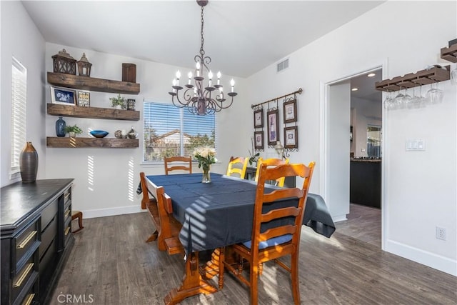 dining area featuring dark hardwood / wood-style flooring and a notable chandelier