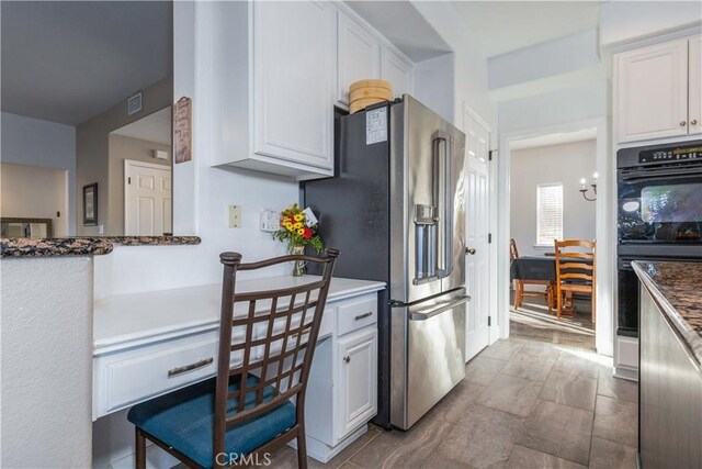 kitchen featuring black double oven, white cabinets, and high end refrigerator