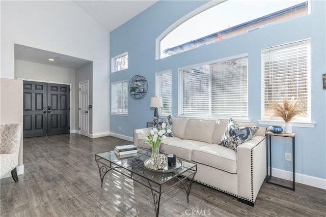 living room featuring a wealth of natural light, dark hardwood / wood-style flooring, and high vaulted ceiling
