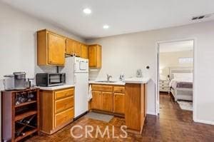 kitchen featuring white refrigerator and sink