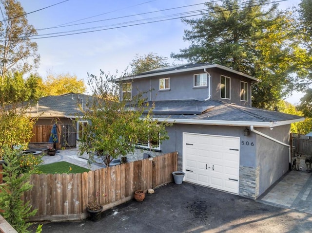 view of front of home featuring a garage and solar panels