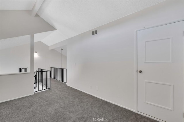 spare room with lofted ceiling with beams and carpet