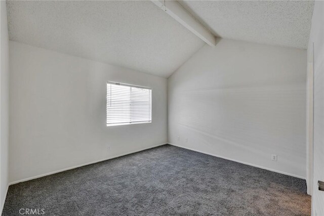 carpeted empty room with vaulted ceiling with beams and a textured ceiling