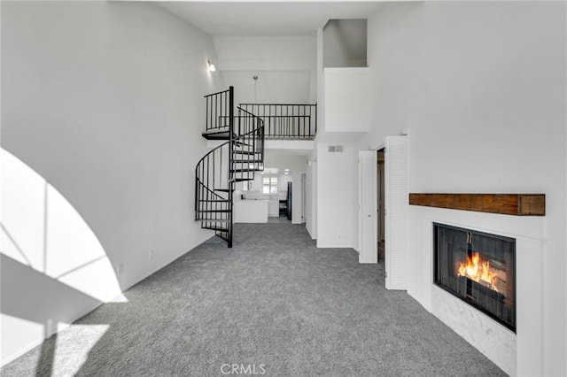 carpeted living room with a high ceiling